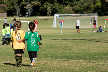 Two girls walking to soccer field